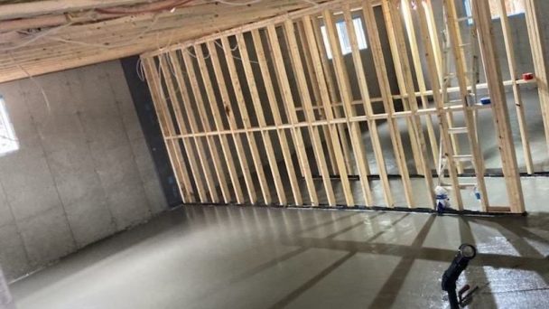 Sous-sol d'une nouvelle résidence avec plancher en béton frais fini à la truelle mécanique